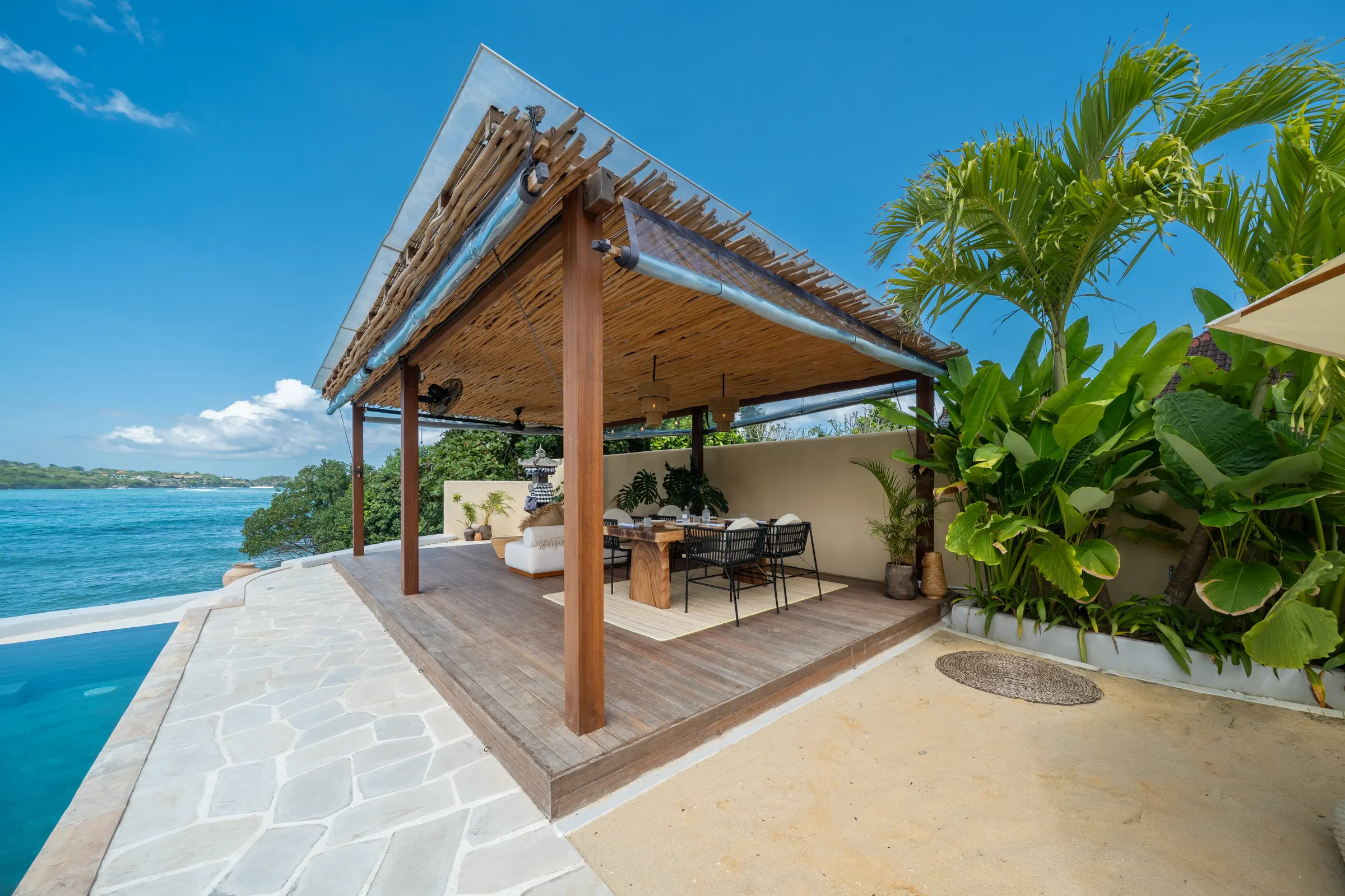 Covered lounge bale beside the pool with a sea view
