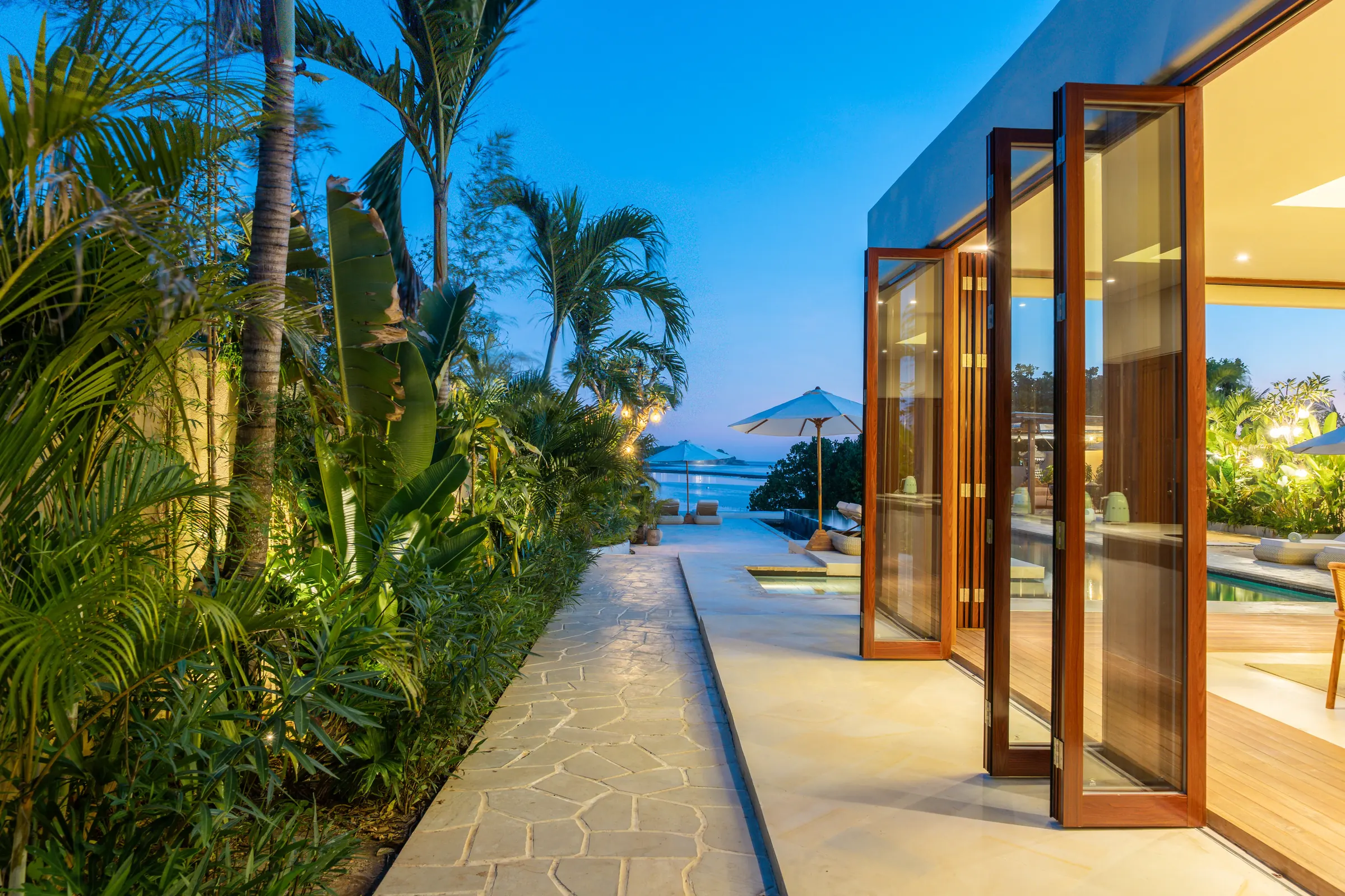 Garden path leading to the pool and sea at dusk, Villa Kingfisher