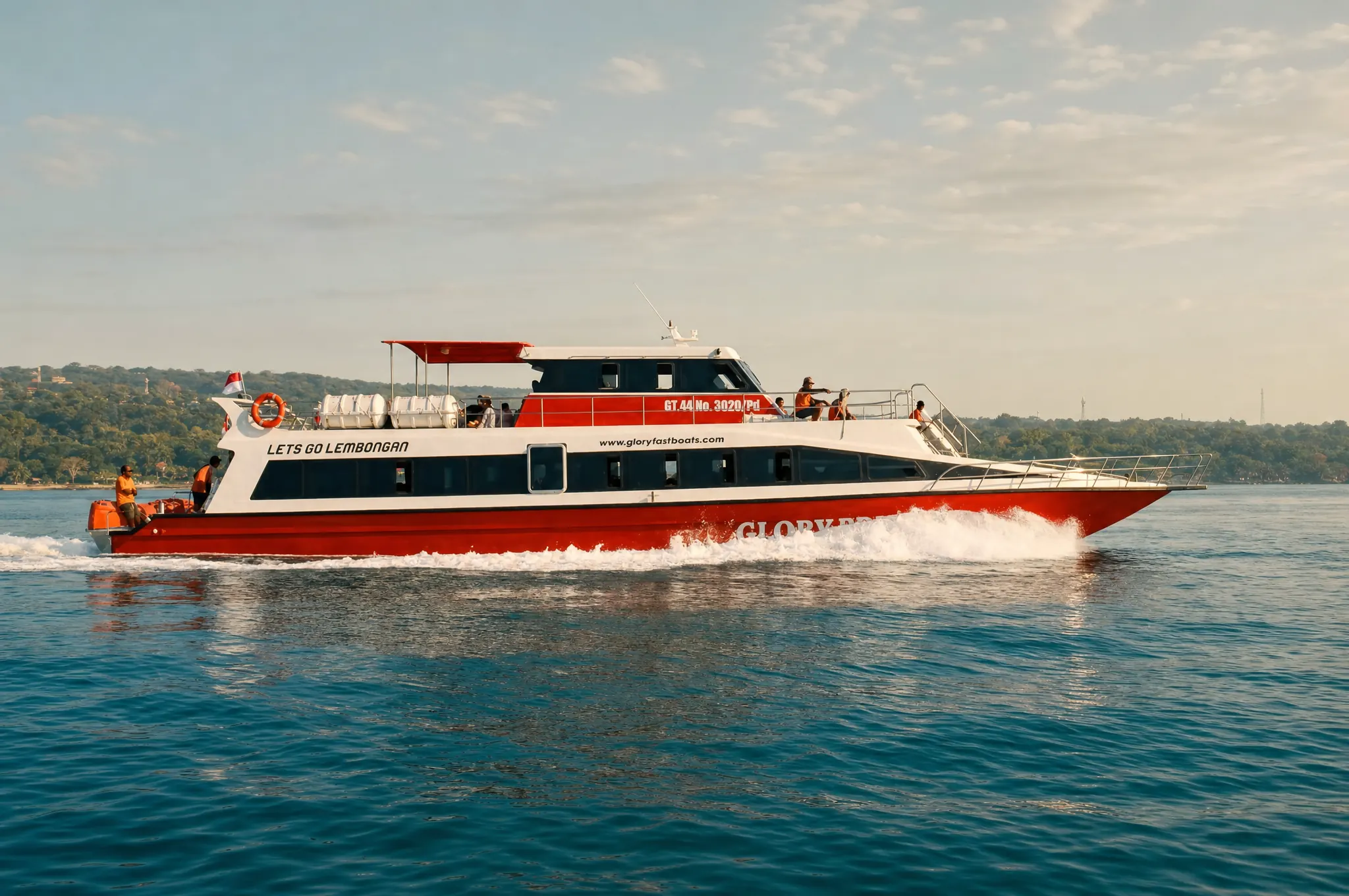 Red fast boat crossing to Nusa Lembongan, Bali coastline behind